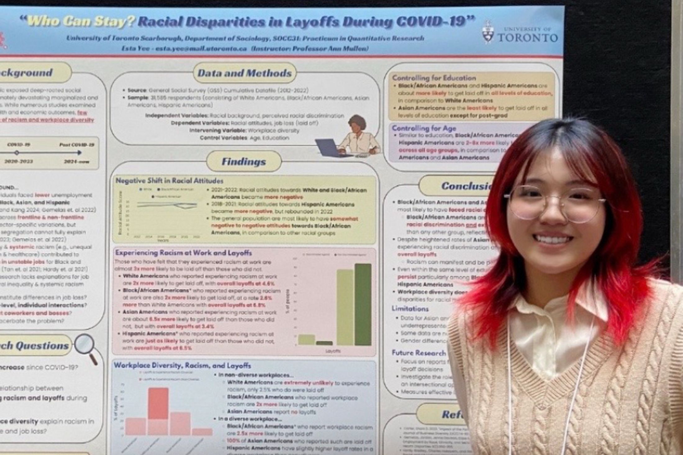 Intern Esta Lee stands in front of a multicoloured poster with research findings on race and job loss during COVID-19