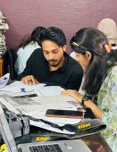 Young man and young woman monitor a newspaper article in Pakistan