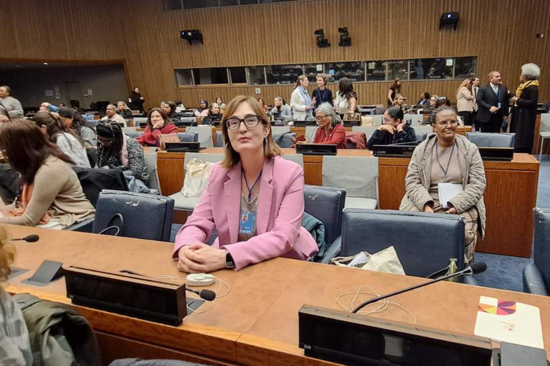 Abida Pehlic sits at a table in an auditorium at the UN with other CSW70 attendees around her