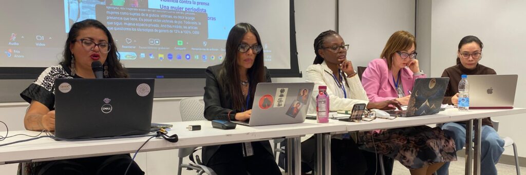 5 women, Cirenia Celestino on the left, sit at a speakers table in a meeting room at the NGO CSW70 Forum.